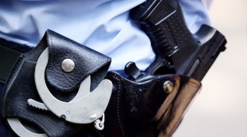 Ein Polizist mit Handschellen und Pistole am Gürtel. / Foto: Oliver Berg/dpa/Symbolbild
