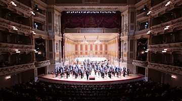 Die Musiker des Orchester der Sächsischen Staatskapelle stehen auf der Bühne. / Foto: Sebastian Kahnert/dpa-Zentralbild/dpa/Archivbild