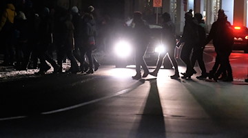 Teilnehmer eines sogenannten Spazierganges gegen die Coronamaßnahmen gehen eine Straße entlang. / Foto: Sebastian Willnow/dpa-Zentralbild/dpa/Symbolbild