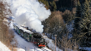 Die Fichtelbergbahn schnauft durch den Winterwald im Erzgebirge. / Foto: Jan Woitas/dpa-Zentralbild/dpa