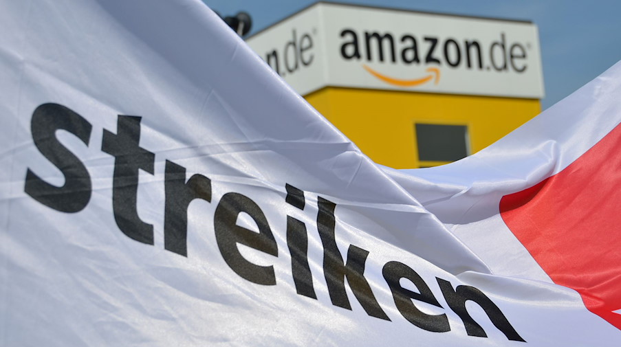 Ein Transparent mit der Aufschrift "streiken" ist vor dem Logistig-Center von Amazon zu sehen. / Foto: Uwe Zucchi/dpa/Archivbild