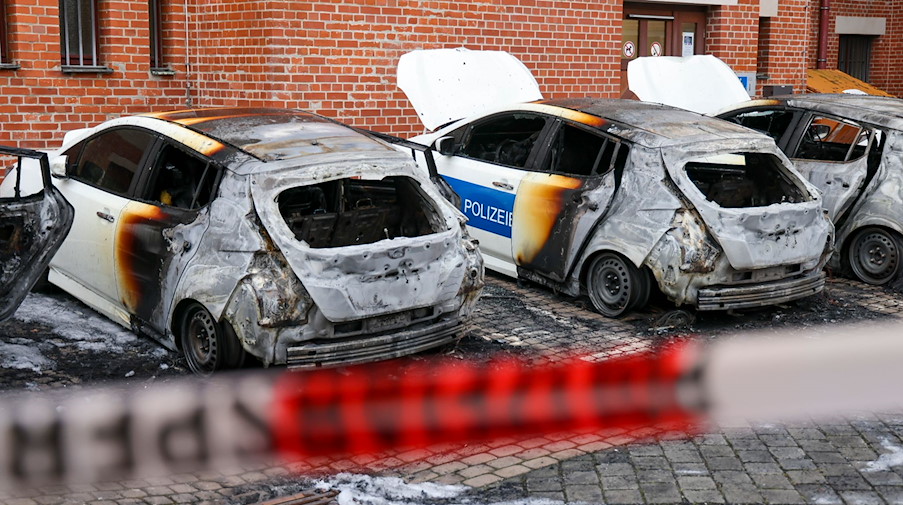 Fahrzeuge der Leipziger Polizeibehörde stehen ausgebrannt auf dem Hof eines Rathauses. / Foto: Jan Woitas/dpa-Zentralbild/dpa
