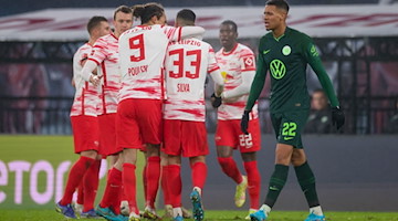 Leipzigs Spieler jubeln nach dem 2:0, während Wolfsburgs Felix Nmecha (r) enttäuscht reagiert. / Foto: Jan Woitas/dpa-Zentralbild/dpa