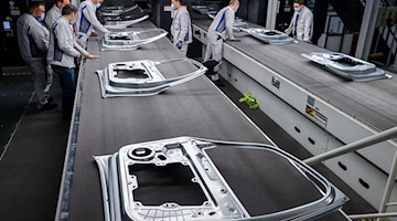 VW-Mitarbeiter kontrollieren Türen nach dem Verlassen der neuen XL-Presse. / Foto: Jan Woitas/dpa-Zentralbild/dpa/Bildarchiv