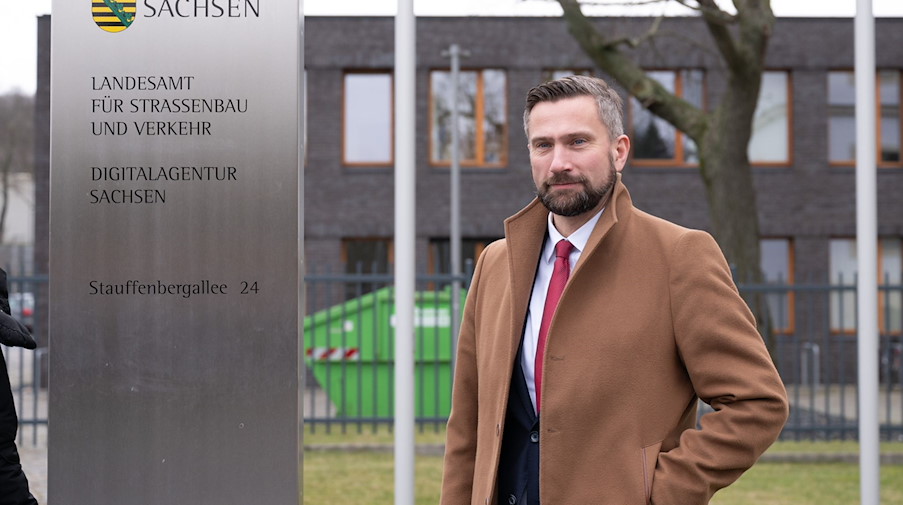 Sachsens Wirtschaftsminister Martin Dulig steht neben einer Stele vor der neuen Digitalagentur. / Foto: Sebastian Kahnert/dpa-Zentralbild/dpa