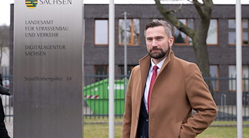 Sachsens Wirtschaftsminister Martin Dulig steht neben einer Stele vor der neuen Digitalagentur. / Foto: Sebastian Kahnert/dpa-Zentralbild/dpa