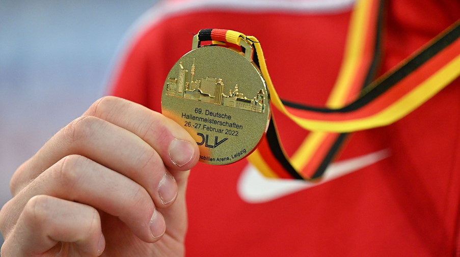 Ein Athlet zeigt seine Goldmedaille während der Deutschen Hallen-Meisterschaft in der Arena Leipzig. / Foto: Martin Schutt/dpa-Zentralbild/dpa