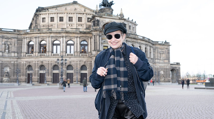 Katharina Thalbach, Schauspielerin und Regisseurin, steht mit einer Zigarette auf dem Theaterplatz vor der Semperoper. / Foto: Sebastian Kahnert/dpa-Zentralbild/dpa