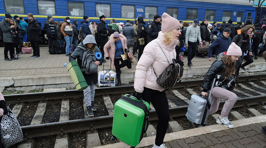 Menschen versammeln sich an einem Bahnhof, um einen Zug zu nehmen und die Ukraine zu verlassen. / Foto: Mykola Tys/AP/dpa/Archivbild