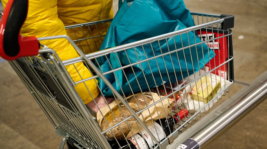 Ein Mann packt seine gekauften Lebensmittel in seine Tüte. / Foto: Annette Riedl/dpa/Symbolbild