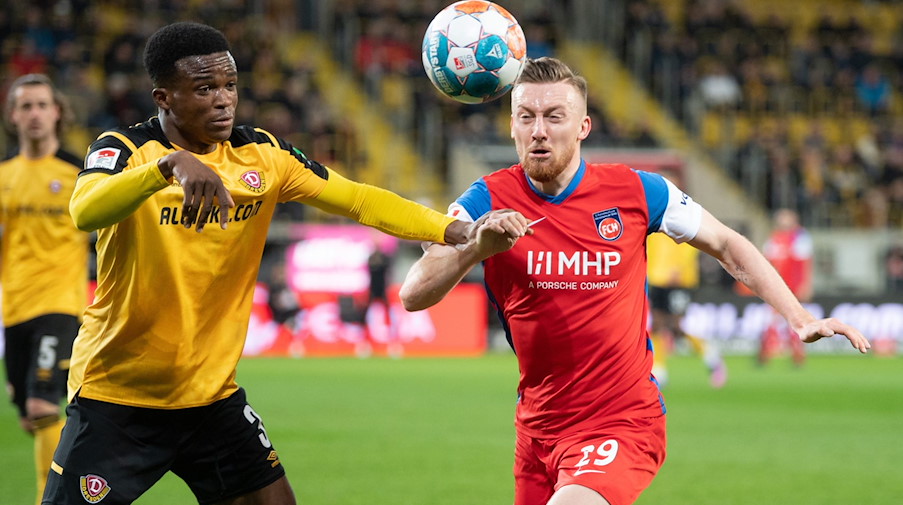 Dynamos Michael Akoto (l) im Zweikampf mit Heidenheims Tobias Mohr. / Foto: Sebastian Kahnert/dpa-Zentralbild/dpa