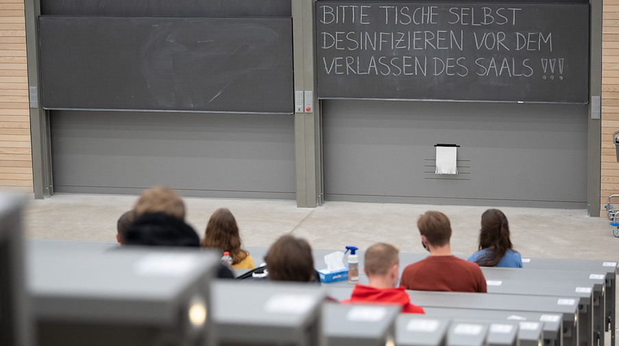 Studierende mit Mund- und Nasenmaske sitzen in einem Hörsaal. / Foto: Sebastian Gollnow/dpa/Symbolbild