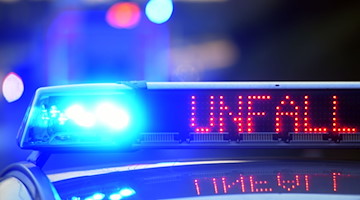 Auf einem Polizeifahrzeug warnt eine Leuchtschrift vor einer Unfallstelle. / Foto: Stefan Puchner/dpa/Symbolbild