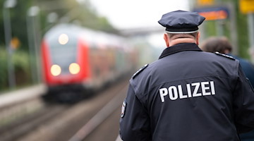 Ein Polizist läuft über einen Bahnsteig. / Foto: Jonas Walzberg/dpa/Symbolbild