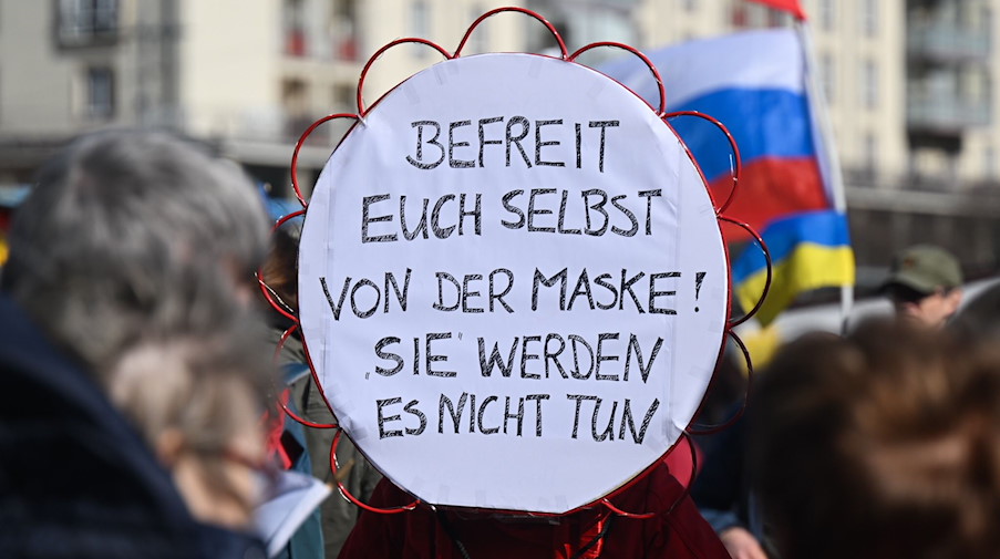 Teilnehmer einer Demonstration von Gegnern der Corona-Maßnahmen stehen auf dem Altmarkt. / Foto: Robert Michael/dpa-Zentralbild/dpa