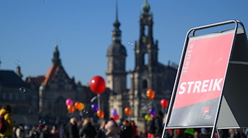 Teilnehmer eines Warnstreiks der Erzieher  stehen mit Luftballons am Elbufer. / Foto: Robert Michael/dpa-Zentralbild/dpa