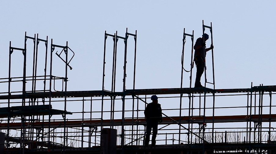 Handwerker arbeiten am Neubau eines Mehrfamilienhauses an einem Baugerüst / Foto: Karl-Josef Hildenbrand/dpa