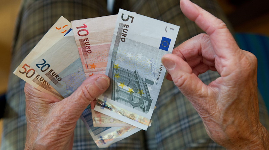 Eine ältere Frau zählt Geld. / Foto: Marijan Murat / dpa/Illustration