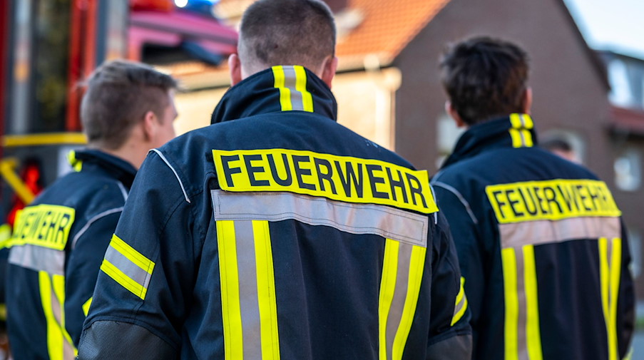Einsatzkräfte der Feuerwehr in Schutzkleidung. / Foto: David Inderlied/dpa/Symbolbild