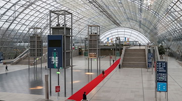 Besucher der Preisverleihung des Preises der Leipziger Buchmesse 2022 gehen über einen roten Teppich in der Glashalle. / Foto: Jan Woitas/dpa-Zentralbild/dpa