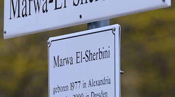 Das Schild für den Marwa-El-Sherbini-Park steht nach seiner Enthüllung vor dem Landgericht. / Foto: Robert Michael/dpa-Zentralbild/dpa