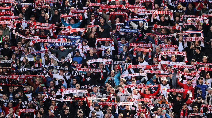Leipzigs Fans halten die Schals vor dem Spiel in die Höhe. / Foto: Jan Woitas/dpa-Zentralbild/dpa