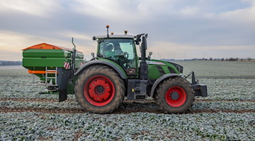 Michael Kretschmer steuert mit Landwirtschaftsmeister Paul Kompe einen Traktor über ein Feld. / Foto: Jan Woitas/dpa-Zentralbild/dpa