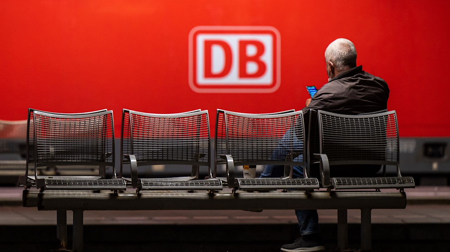 Ein Mann wartet auf einer Bank in einem Hauptbahnhof. / Foto: Peter Kneffel/dpa/Symbolbild