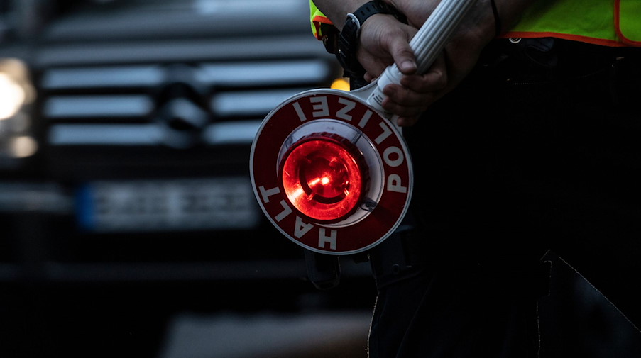 Ein Polizist hält bei einer Verkehrskontrolle eine Winkerkelle in der Hand. / Foto: Paul Zinken/dpa/Symbolbild