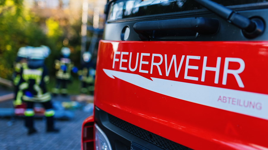 Feuerwehrleute stehen hinter einem Einsatzfahrzeug. / Foto: Philipp von Ditfurth/dpa/Symbolbild