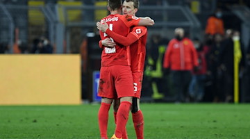 Willi Orban (l) und Lukas Klostermann umarmen sich nach einem Spiel. / Foto: Bernd Thissen/dpa