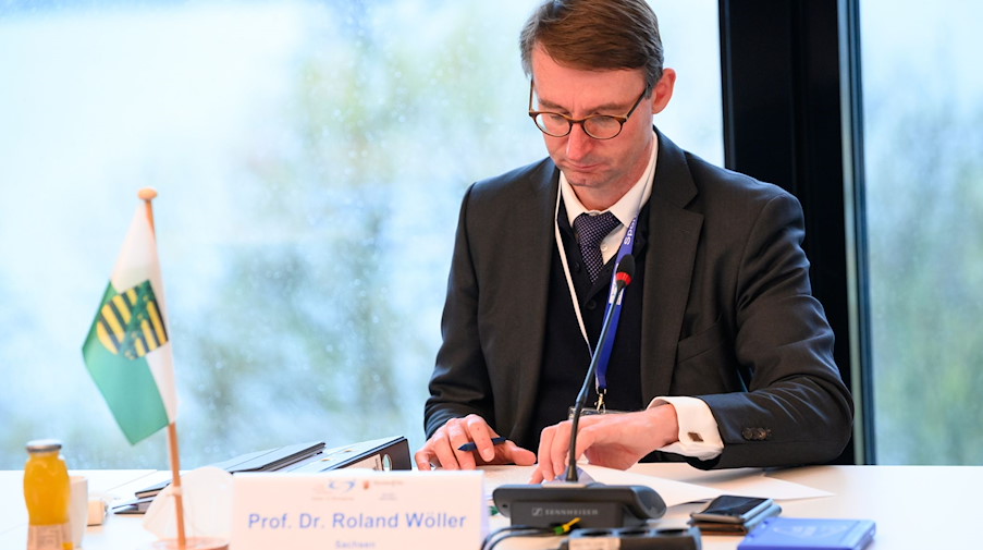 Roland Wöller (CDU), Innenminister von Sachsen, sitzt an einem Tisch. / Foto: Jonas Walzberg/dpa