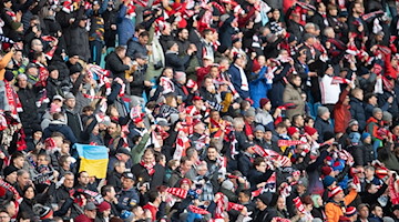 Die Leipziger Fans stehen vor dem Spiel im Stadion. / Foto: Sebastian Kahnert/dpa/Archivbild
