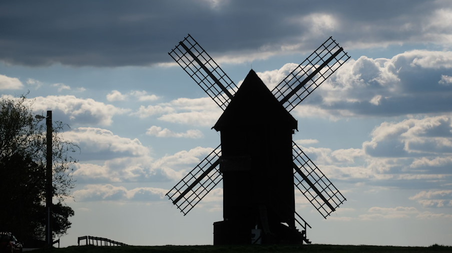 Eine Windmühle am Rande eines Dorfes. / Foto: Sebastian Willnow/dpa
