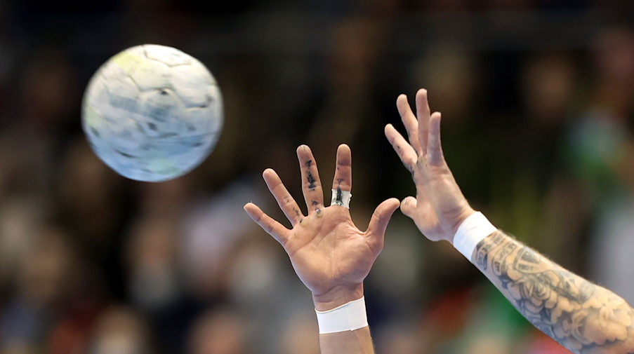 Ein Handballspieler fängt den Ball. / Foto: Ronny Hartmann/dpa/Symbolbild