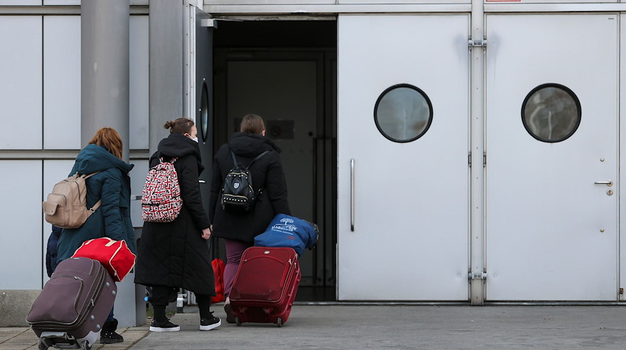 Aus der Ukraine geflüchtete Menschen gehen in eine Erstaufnahmeeinrichtung auf der Leipziger Messe. / Foto: Jan Woitas/dpa-Zentralbild/dpa
