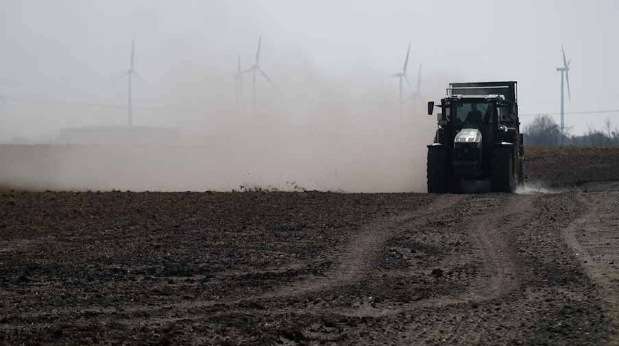 Ein Traktor bringt Dünger auf einen Acker aus, wobei als Folge von Dürre und Trockenheit viel Staub aufgewirbelt wird. / Foto: Sebastian Willnow/dpa-Zentralbild/dpa/Symbolbild