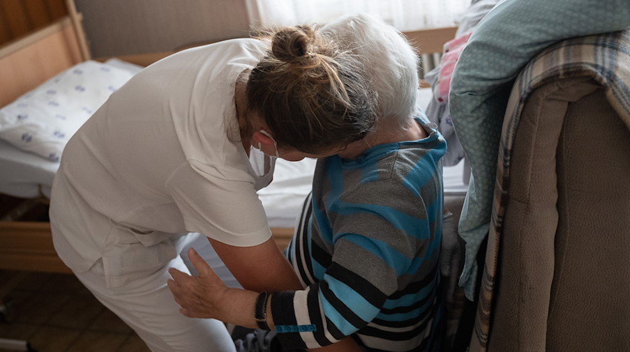 Eine Pflegefachkraft hilft in der ambulanten Pflege einer Frau beim Umsetzen. / Foto: Sebastian Gollnow/dpa/Symbolbild