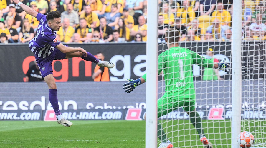 Aues Nicolas Kühn (l) erzielt gegen Dynamos Torwart Kevin Broll das Tor zum 0:1. / Foto: Robert Michael/dpa