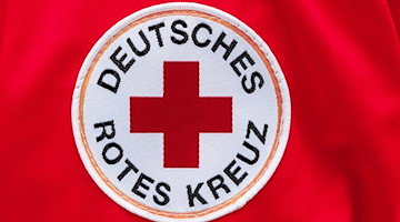 Ein Aufnäher mit dem Logo des Deutschen Roten Kreuzes (DRK). / Foto: Markus Scholz/dpa