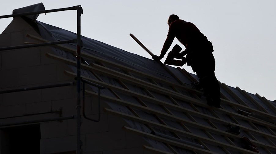 Ein Dachdecker arbeitet auf einem Einfamilienhaus am Leipziger Stadtrand. / Foto: Jan Woitas/dpa/Symbolbild