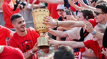 Leipzigs André Silva zeigt den zahlreichen Fans den DFB-Pokal während der Meisterfeier auf der Festwiese. / Foto: Jan Woitas/dpa