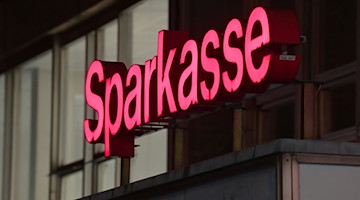 Der rote Schriftzug "Sparkasse" über dem Eingang zur Filiale der Mittelbrandenburgischen Sparkassen. / Foto: Soeren Stache/dpa-Zentralbild/dpa/Archivbild