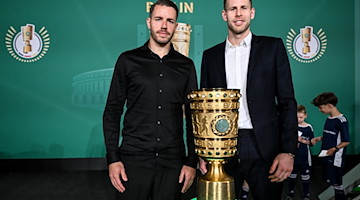 Freiburgs Christian Günter (l) und Leipzigs Torwart Peter Gulacsi stehen neben dem DFB-Pokal. / Foto: Britta Pedersen/dpa/Archivbild