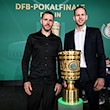 Freiburgs Christian Günter (l) und Leipzigs Torwart Peter Gulacsi stehen neben dem DFB-Pokal. / Foto: Britta Pedersen/dpa/Archivbild