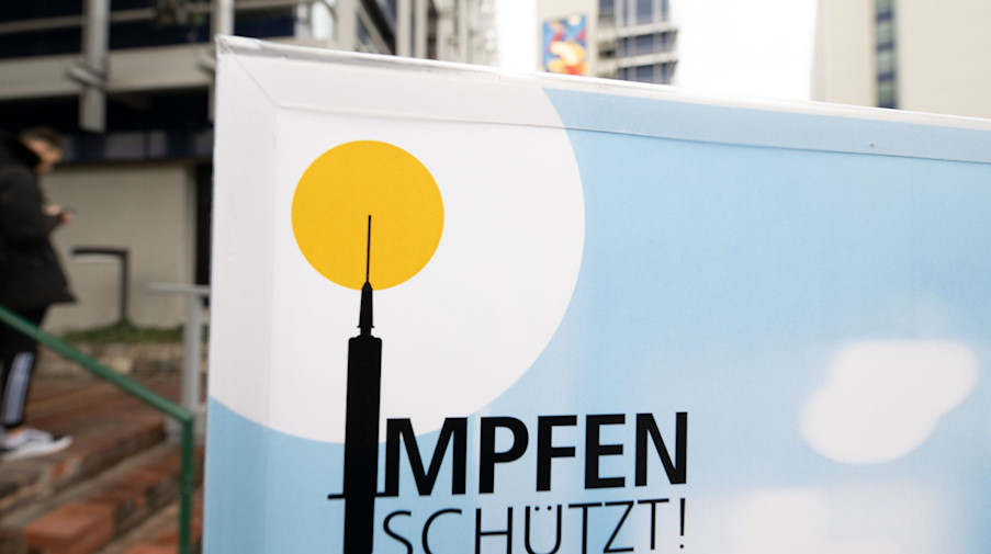 Ein Plakat mit der Aufschrift «Impfen schützt» steht vor einem Impfzentrum. / Foto: Bernd Weißbrod/dpa/Symbolbild