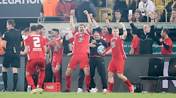 Die Spieler von Kaiserslautern jubeln nach dem Aufstieg in die 2. Bundesliga. / Foto: Jan Woitas/dpa