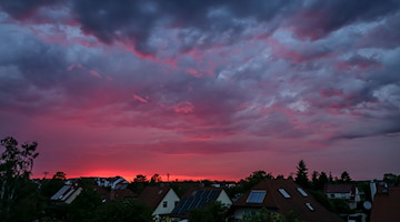 Die untergehende Sonne beleuchtet die aufziehenden Gewitterwolken über dem Leipziger Westen. / Foto: Jan Woitas/dpa
