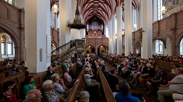 Gäste der Thomaskirche Leipzig hören die Orgelmusik von Thomasorganist Johannes Lang. / Foto: Hendrik Schmidt/dpa