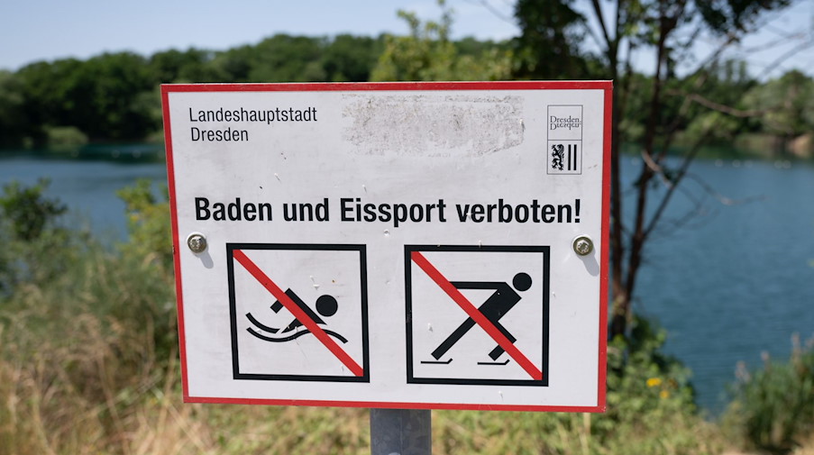 Ein Schild mit der Aufschrift «Baden und Eissport verboten» steht vor der Kiesgrube Leuben. / Foto: Sebastian Kahnert/dpa-Zentralbild/dpa/Archivbild